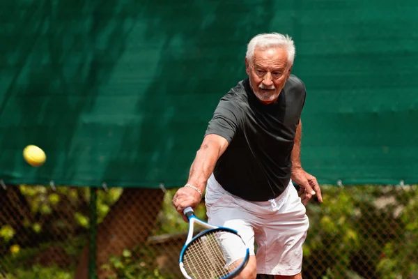 Homme âgé actif jouant au tennis — Photo