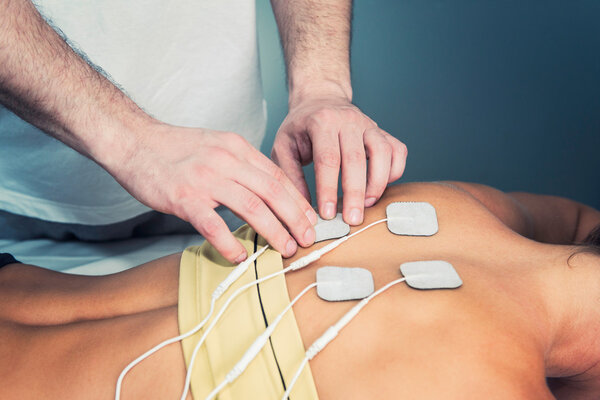 therapist positioning electrodes on patient back