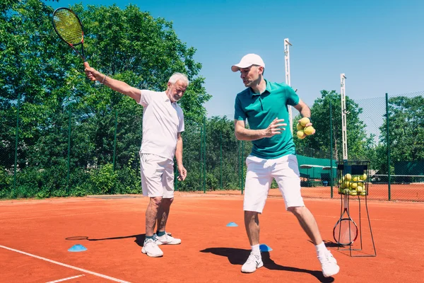 Äldre man har tennis lektion — Stockfoto