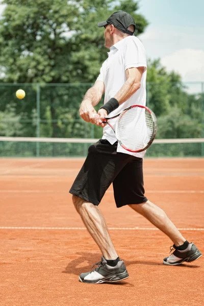 Jugador de tenis golpeando revés — Foto de Stock