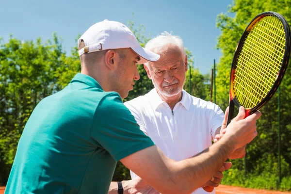 Starší muž na tenisové lekce — Stock fotografie