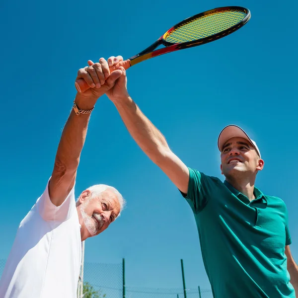 Tennislärare med äldre man — Stockfoto