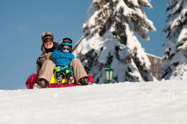 Mutter und Sohn beim Schneetreiben den Berg hinunter — Stockfoto