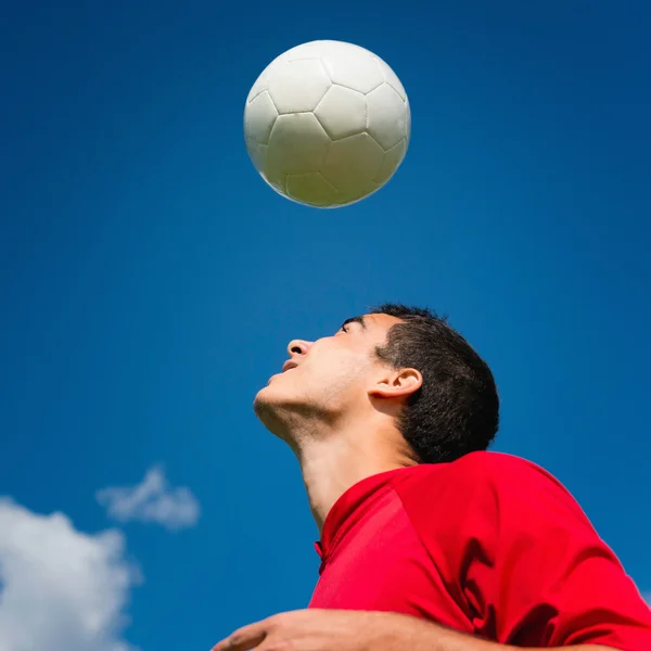 Joueur de football avec ballon au-dessus de la tête — Photo