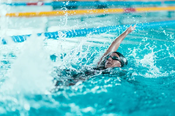 Atleta feminino nadando na piscina — Fotografia de Stock