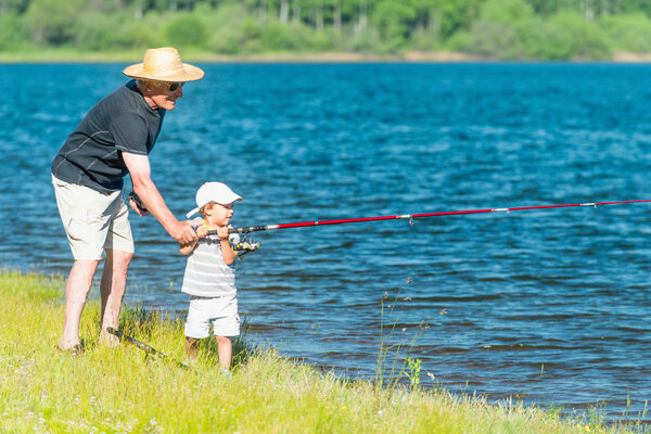 grandson fishing with grandfather