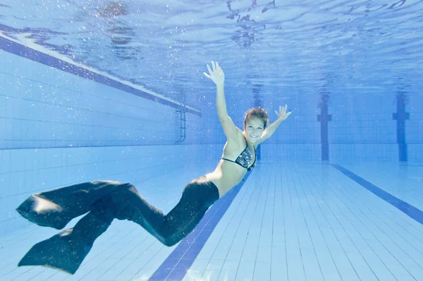 Frau im Meerjungfrauenkostüm schwimmt im Pool — Stockfoto