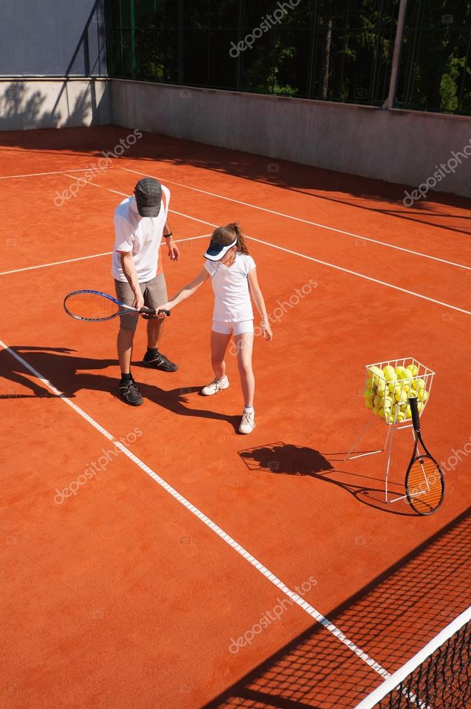 Junior Tennis player with instructor Stock Photo by ©microgen 115174684