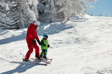 Ski instructor and a little boy clipart