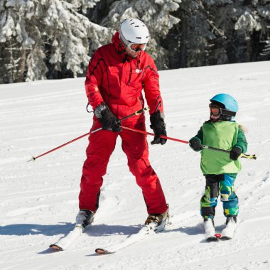  boy skiing with instructor clipart