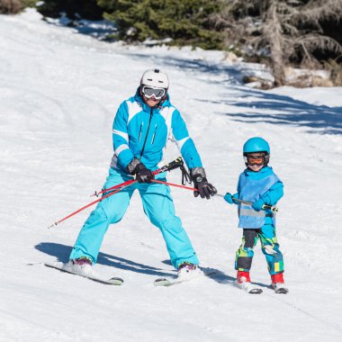 Father and son skiing on mountain hill clipart