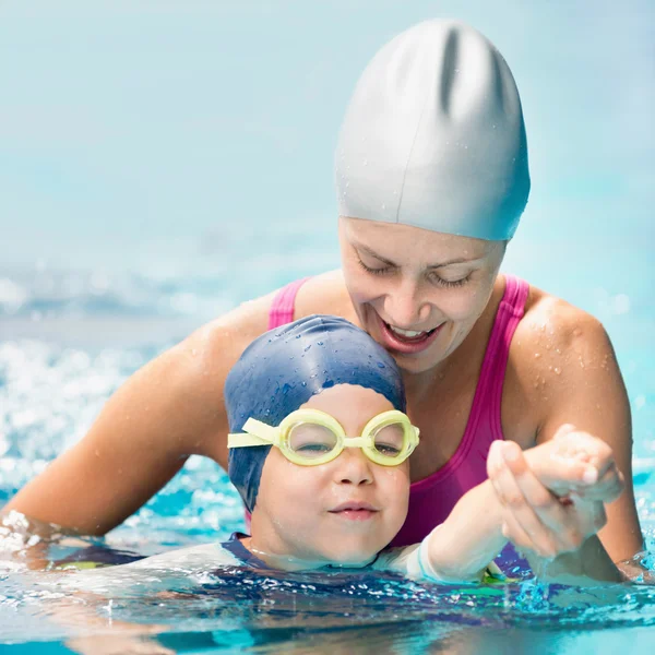 Swimming instructor teaching child to swim — Stock Photo, Image