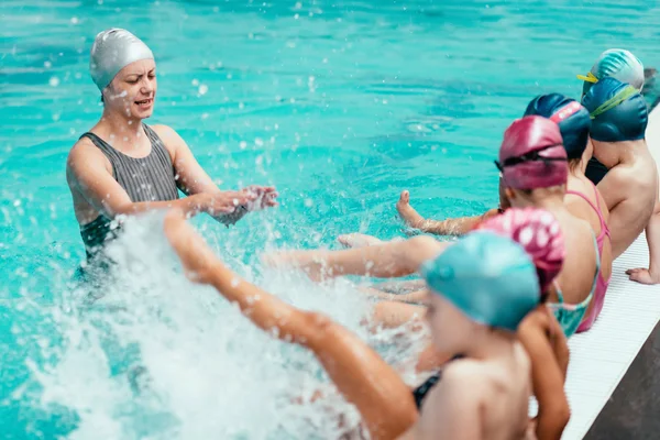 Swimming instructor with group of kids — Stock Photo, Image