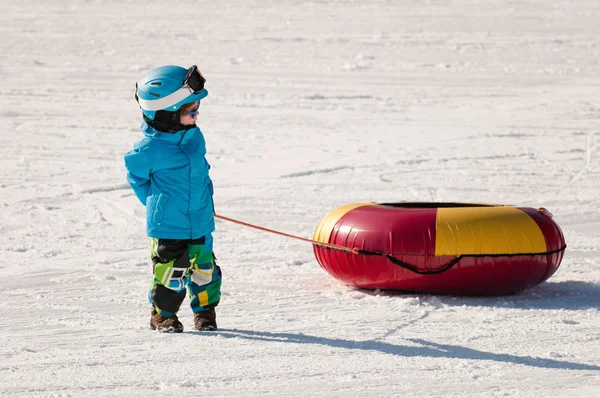 Petit garçon se préparant pour les tubes à neige — Photo