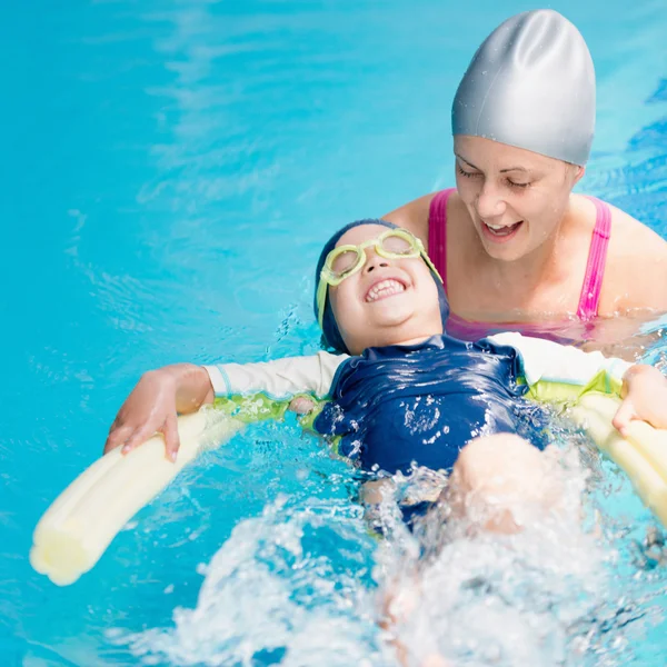 Ragazzo nuotare sul retro con piscina tagliatella — Foto Stock