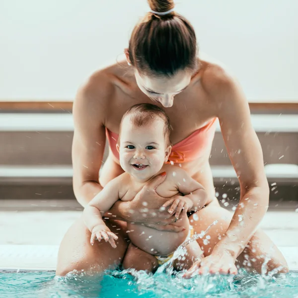 Mãe com bebê na borda da piscina — Fotografia de Stock