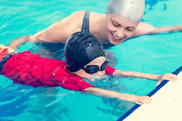 Little child making bubbles in swimming class — Stock Photo, Image