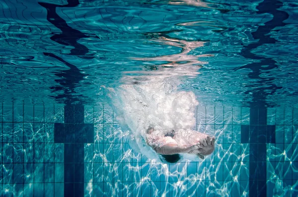 Kvinde dykker ned i swimmingpool - Stock-foto