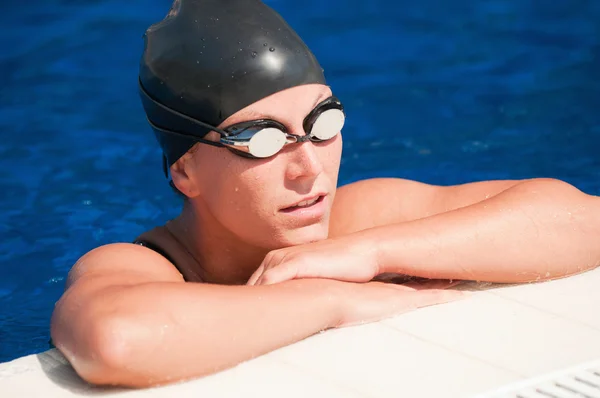 Nadador feminino descansando ao lado da piscina — Fotografia de Stock