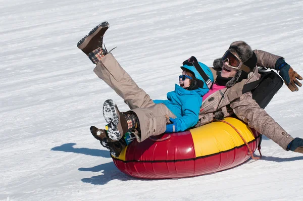 Mãe e filho neve tubulação descendo colina — Fotografia de Stock