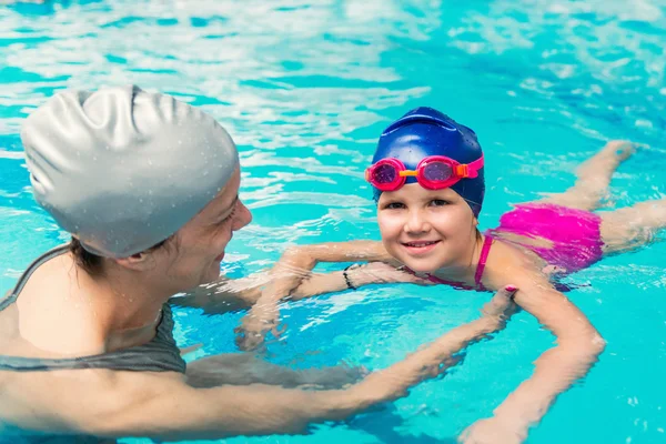 Meisje leren om te zwemmen met instructeur — Stockfoto