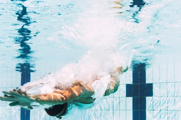 Kvinde dykker ned i swimmingpool - Stock-foto