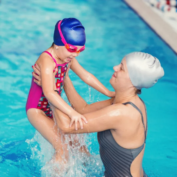 Woman and girl having fun in pool — Stock Photo, Image