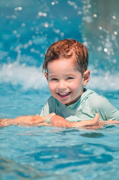 Boy in swimming pool holiding parents hand — Stock Photo, Image