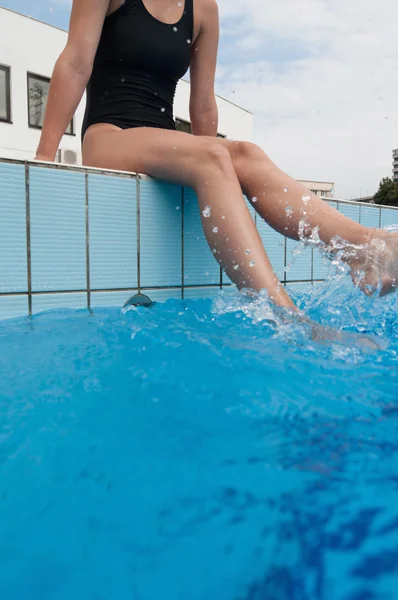 Donna piedi spruzzi a bordo piscina — Foto Stock