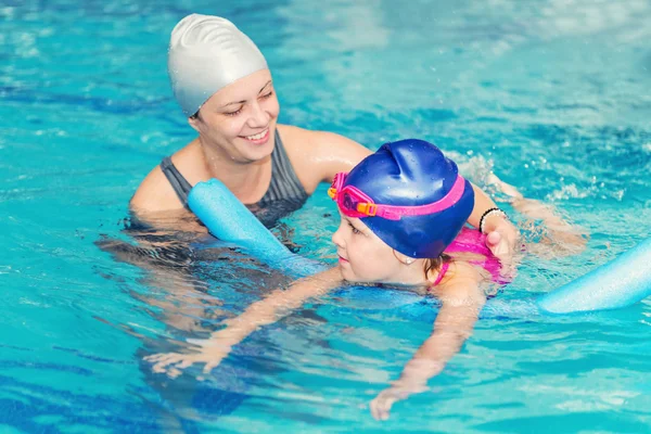 Little girl learning to swim with instructor — Stock Photo, Image