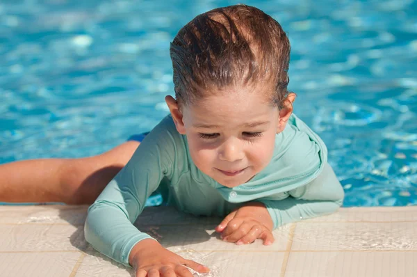 Boy climbing out of swimming pool — Stock Photo, Image