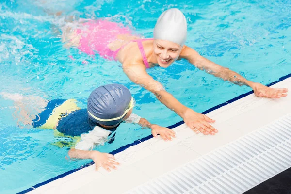 Vrouwelijke instructeur en de kleine jongen in een pool — Stockfoto