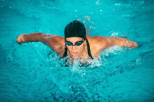 Kvinnelig idrettsutøver som svømmer i basseng – stockfoto
