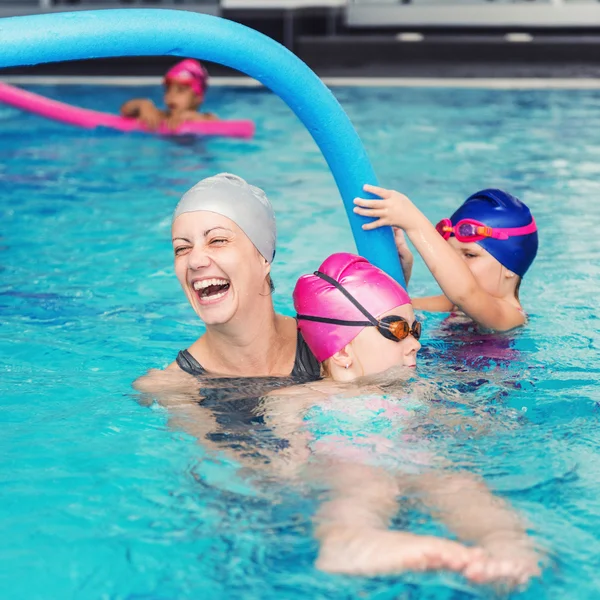 Kids having fun with swimming instructor — Stock Photo, Image