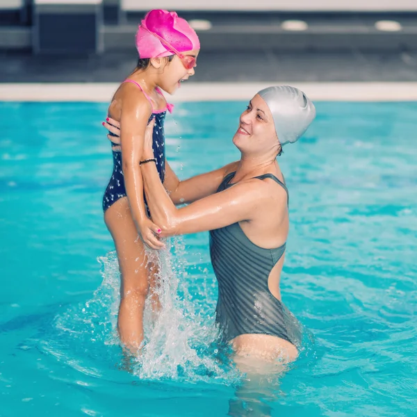 Mulher e menina se divertindo na piscina — Fotografia de Stock