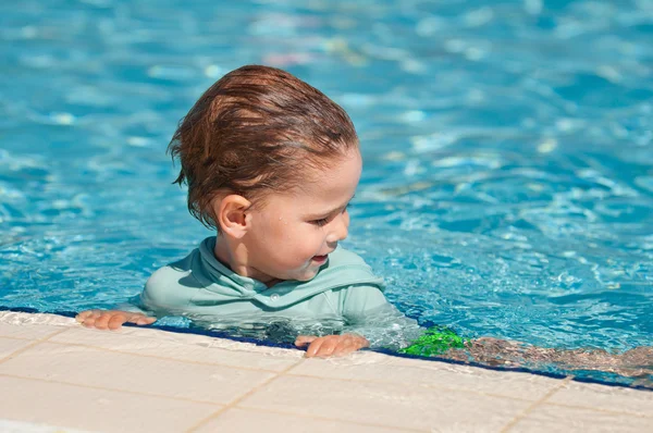 Little boy hanging on pool side — Stock Photo, Image
