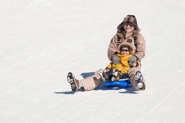 Mãe e filho curtindo trenó de neve — Fotografia de Stock