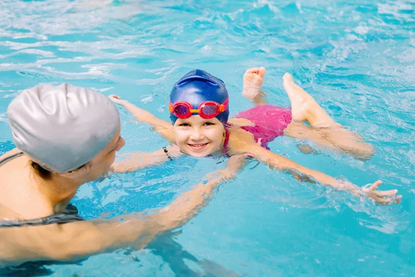 Niña aprendiendo a nadar con el instructor — Foto de Stock