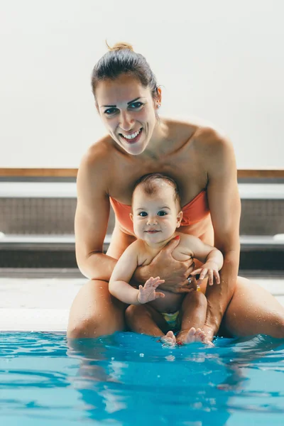 Mãe e bebê menino na borda da piscina — Fotografia de Stock