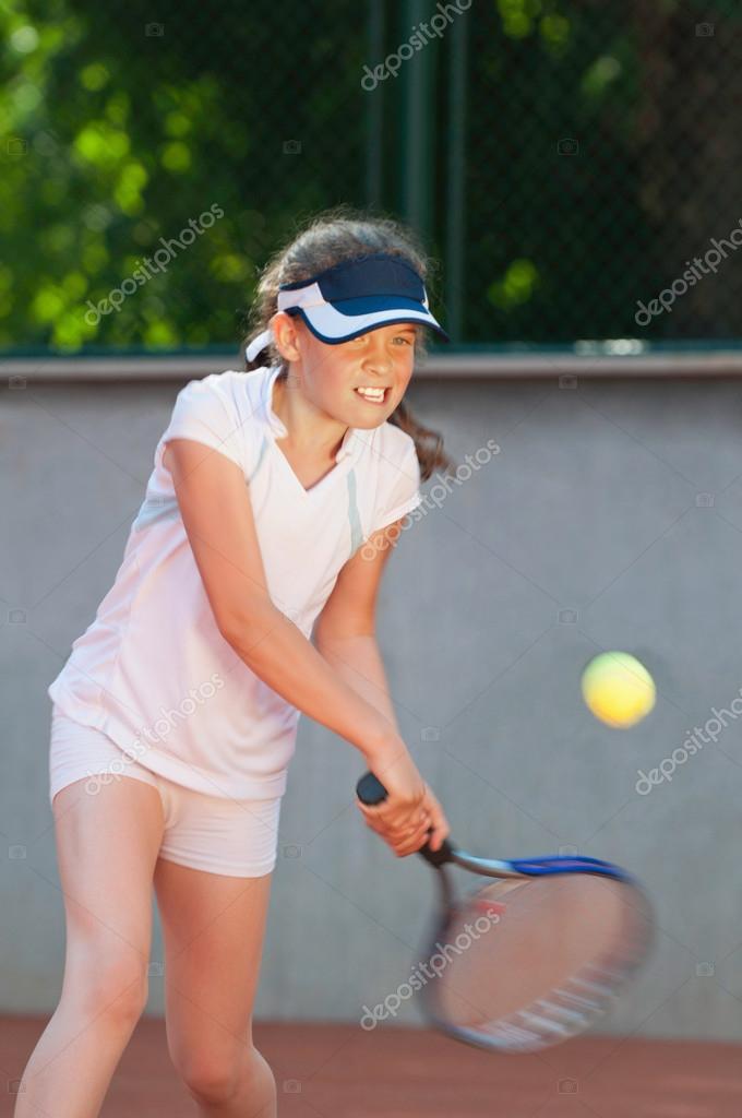 Junior tennis player hitting the ball Stock Photo by ©microgen 115183112