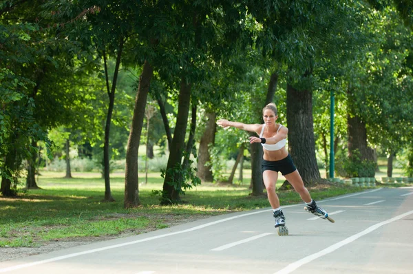 Mulher patinação rolo através do parque — Fotografia de Stock