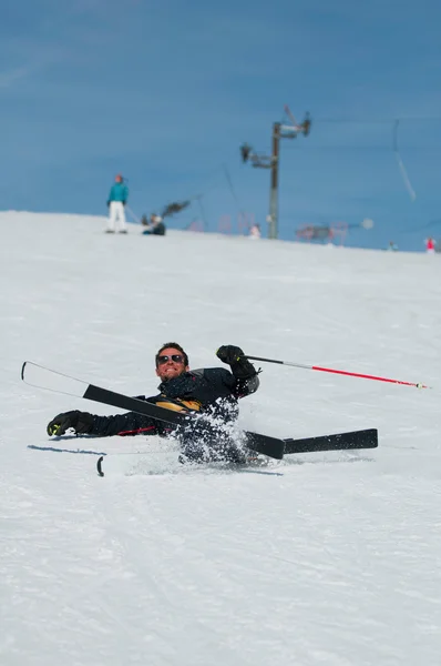 Skier falder ned på skibakken - Stock-foto