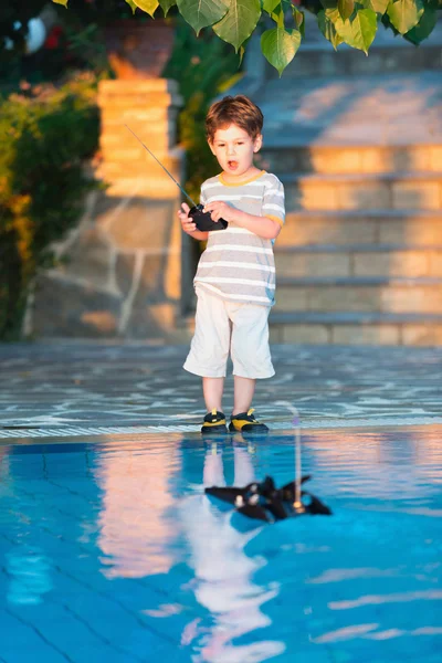 Little boy playing with remote control boat