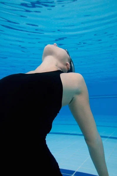 Mujer flotando en la piscina — Foto de Stock