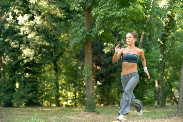 Junge Frau joggt im Park — Stockfoto