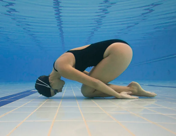 Mujer en posición bajo el agua en la piscina — Foto de Stock