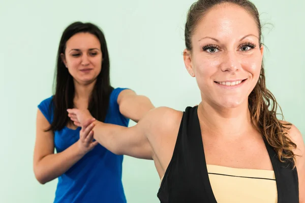 Kvinnan gör arm stretching motion — Stockfoto