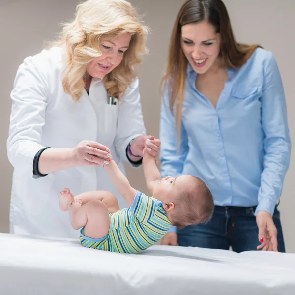 Pediatra haciendo examen médico con el bebé — Foto de Stock