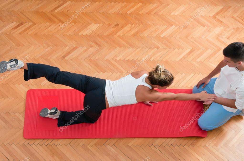 Therapist helping an athlete to stretch muscles — Stock Photo