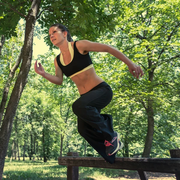 Atleta atravessando barreiras de madeira — Fotografia de Stock